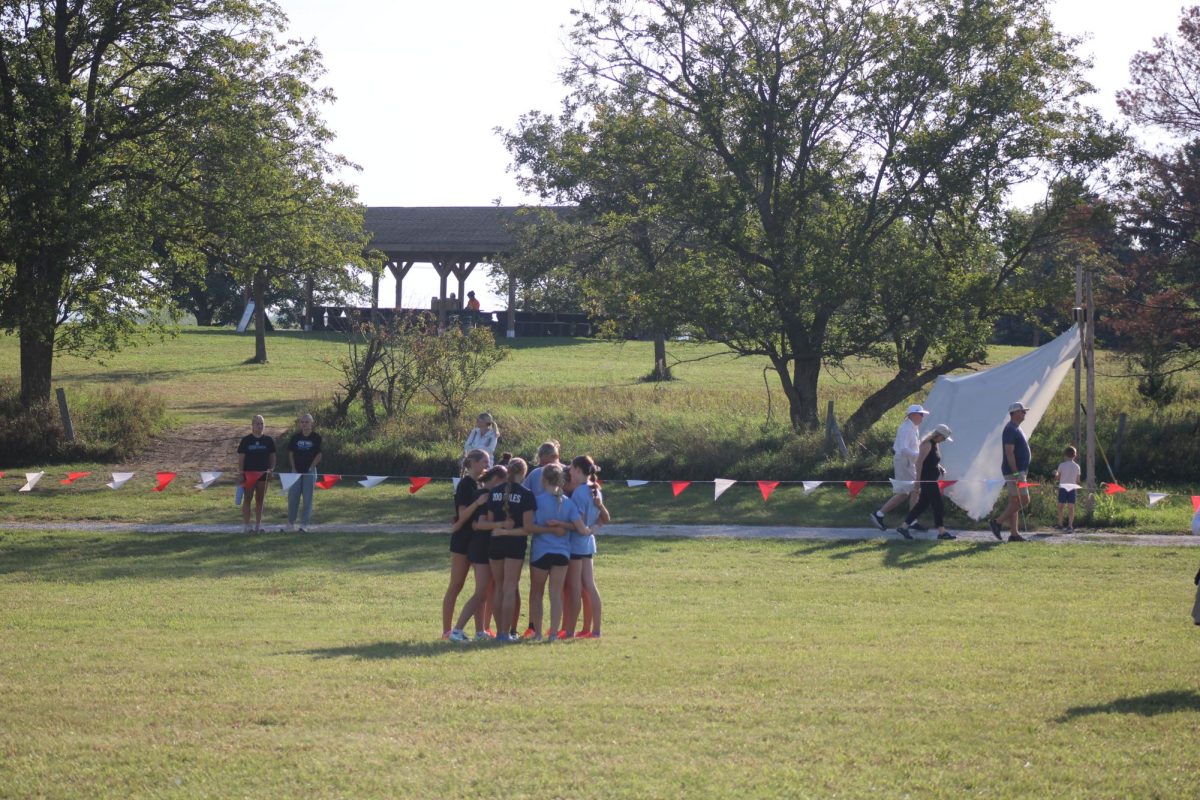 The girls varsity cross country team praying in their circle before the meet. They do this together at every event. 