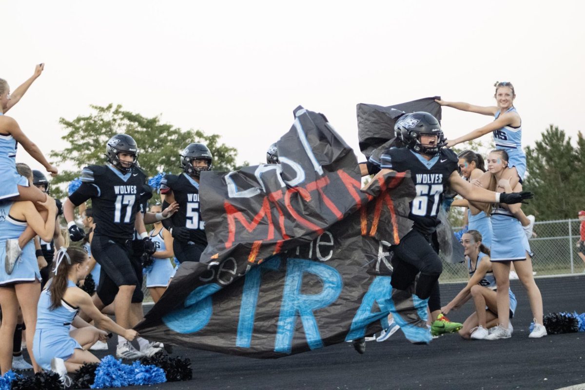 The Wolves run out of the locker room and onto the field. Senior Shane Heida (67) led the pack. 