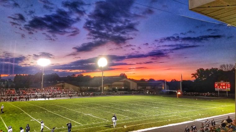 A sunset picture over a highschool football game. This shows the environment and feel of friday night lights.