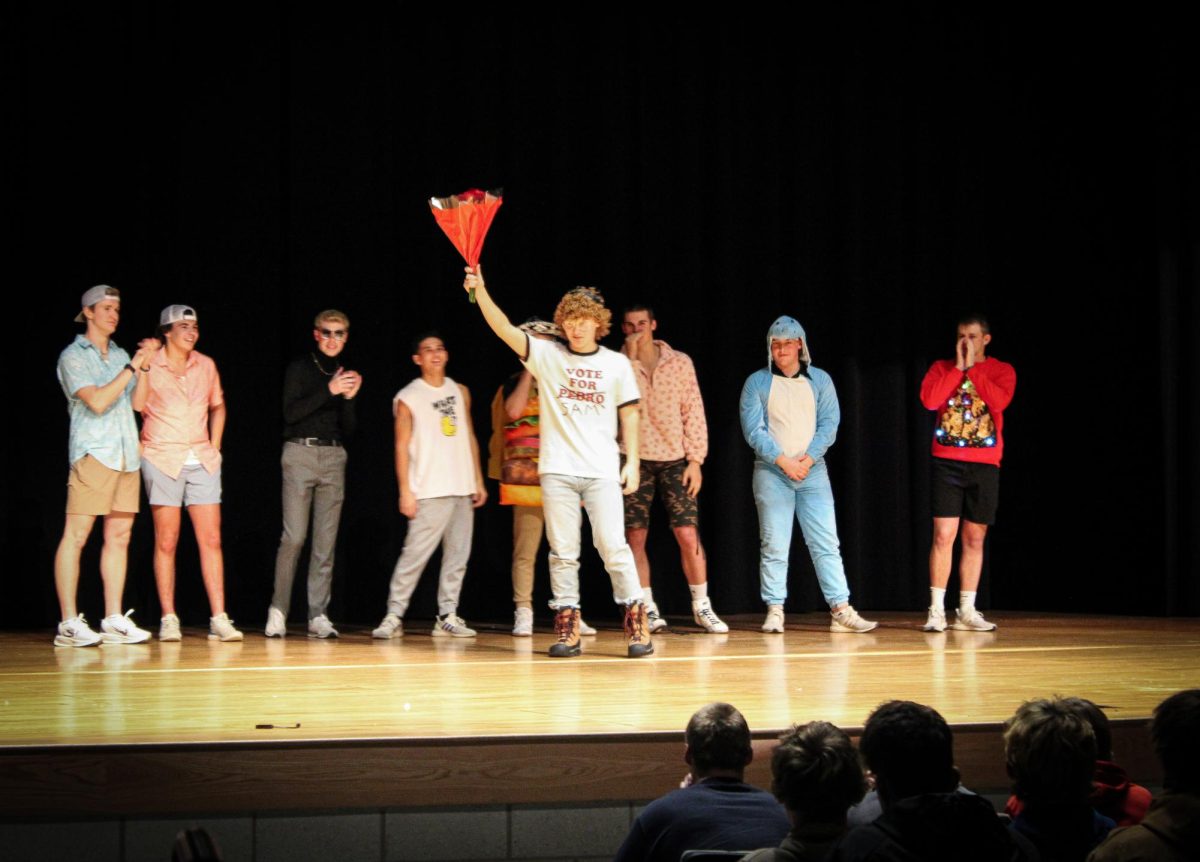 Senior Sam Hunsberger hosts flowers at the senior showcase. Hunsberger won the competition and became Alpha of the Pack.