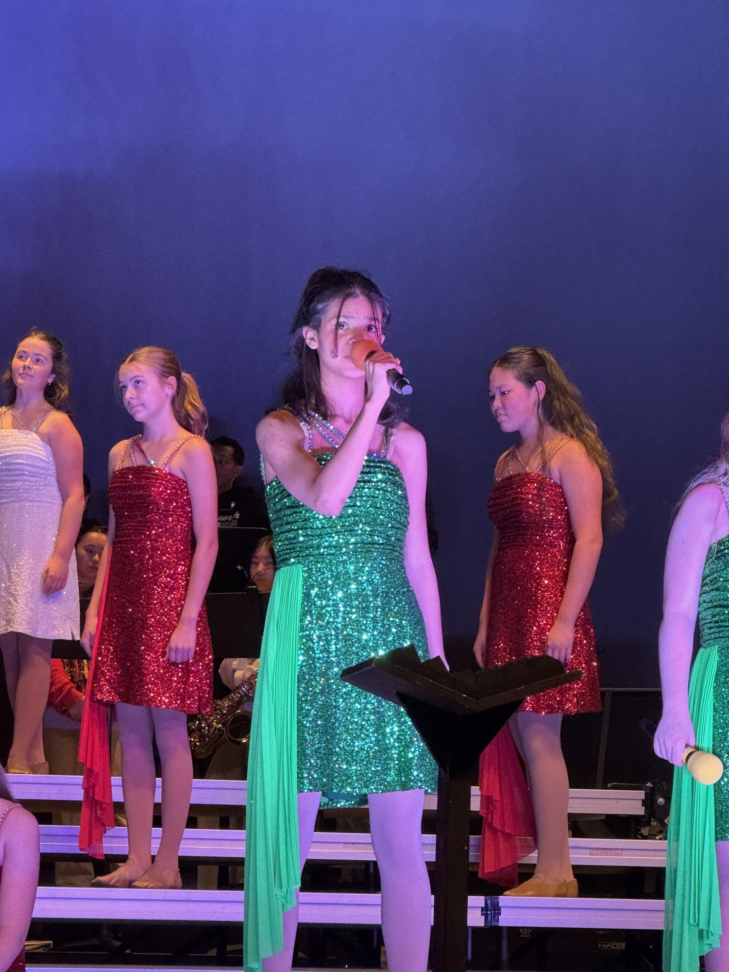 Nengsu stands in front of the crowd to perform her part of the duet. Sydney Sweeney also sang with her. 