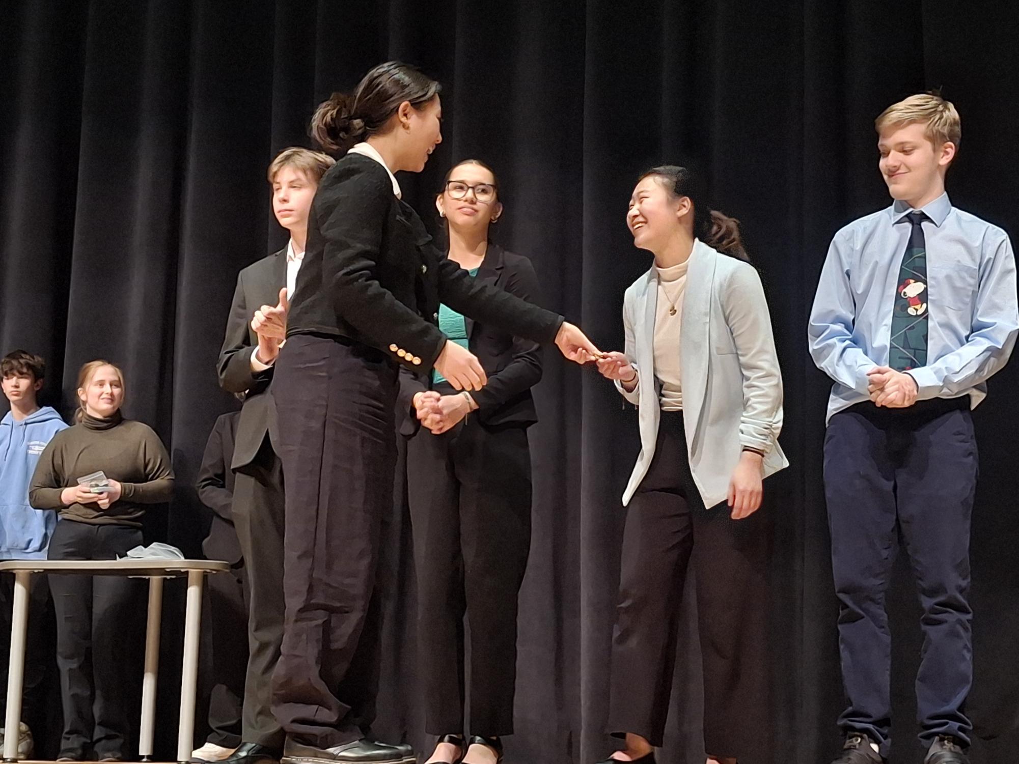 Sophomore Ellie Duan accepts a medal for Entertainment Speaking. Performers in the entertainment must have a visual aid and comedic aspects to their speech.