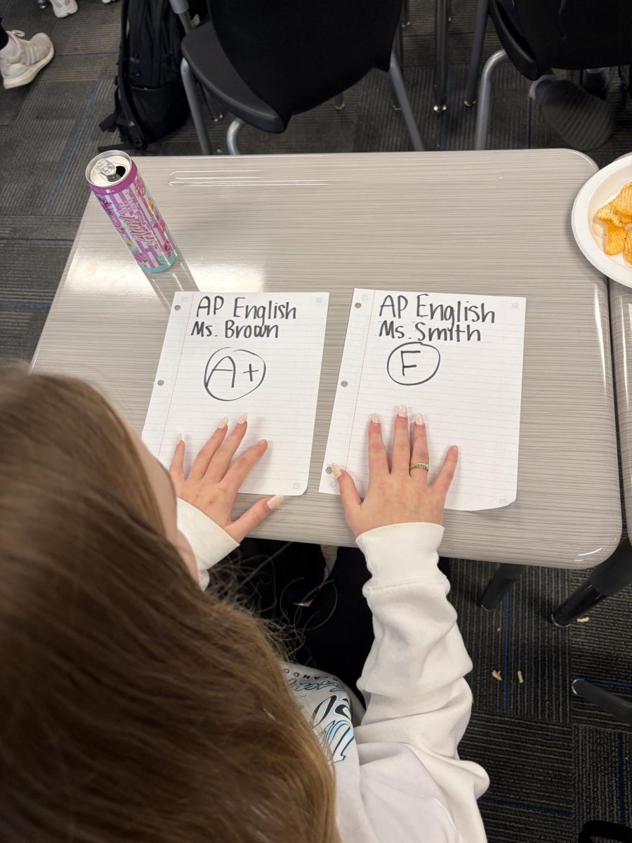 Junior Hannah Skudlarek looks at two different assignments in the same course, but completely different grades. Two different teachers can lead students to having grades completely differing from each other. Photo by Harper Wills