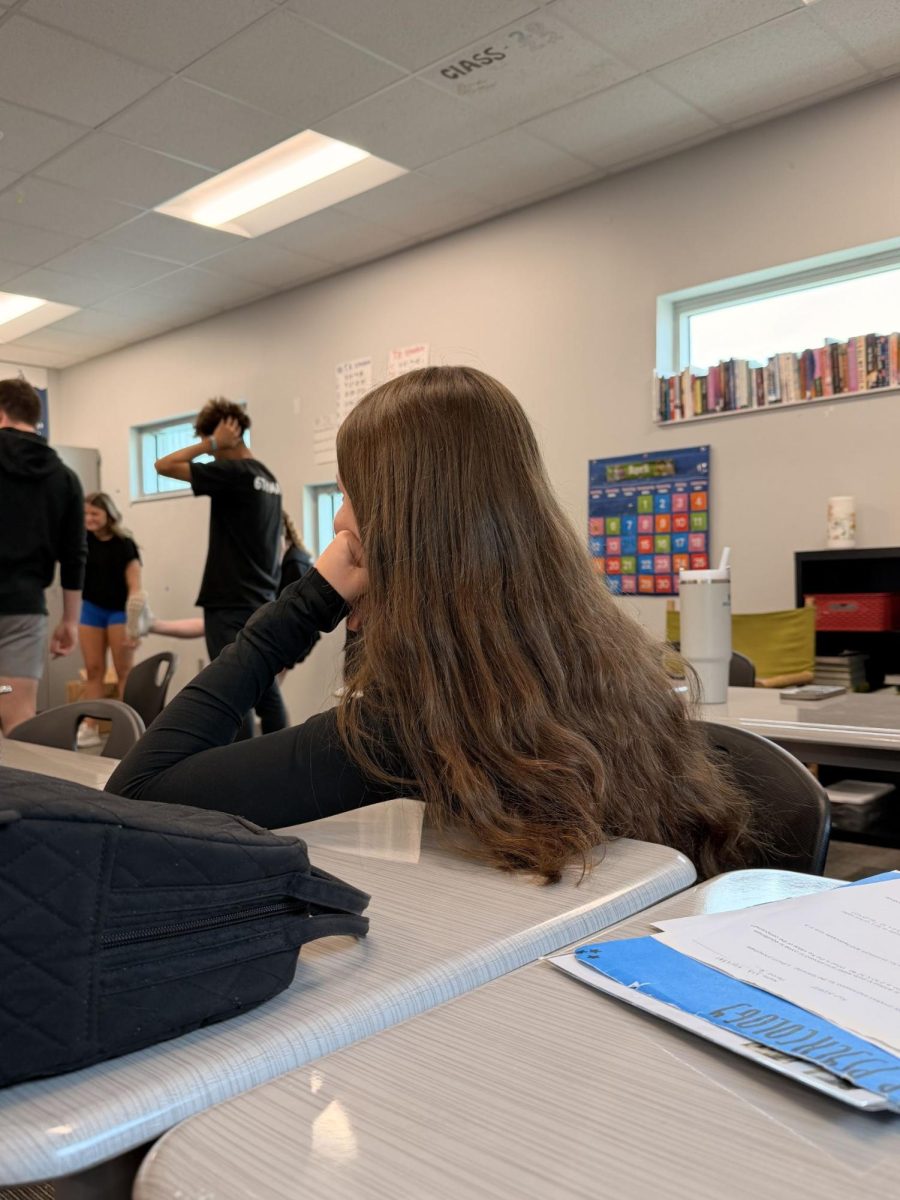 Sophomore Channing Sidders sits in class watching her classmates. They are playing a game that she is not involved in, leading to an increase in her FOMO. 